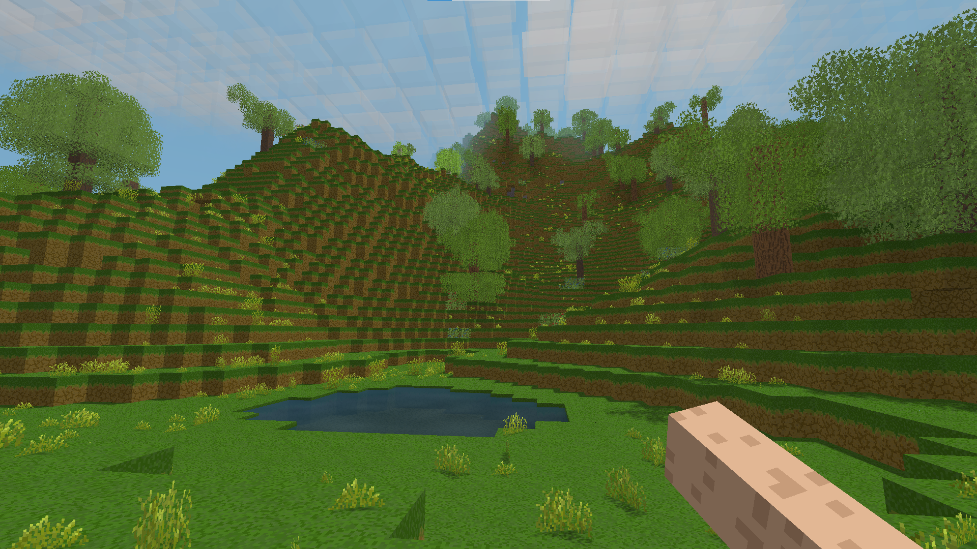 A vast voxel landscape with rolling hills and forests under a bright sky